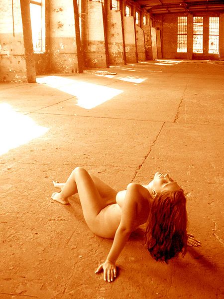 Redhead nude babe laying on the concrete floor