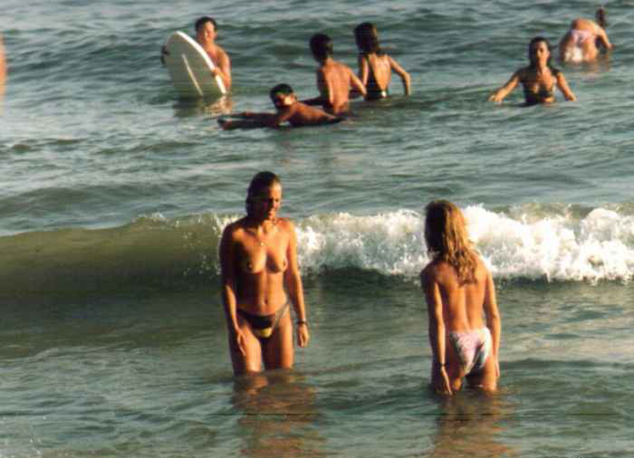 Topless teens in the warm sea water
