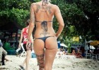 Tattooed blonde showing her nice ass in a thong bikini