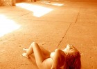 Redhead nude babe laying on the concrete floor