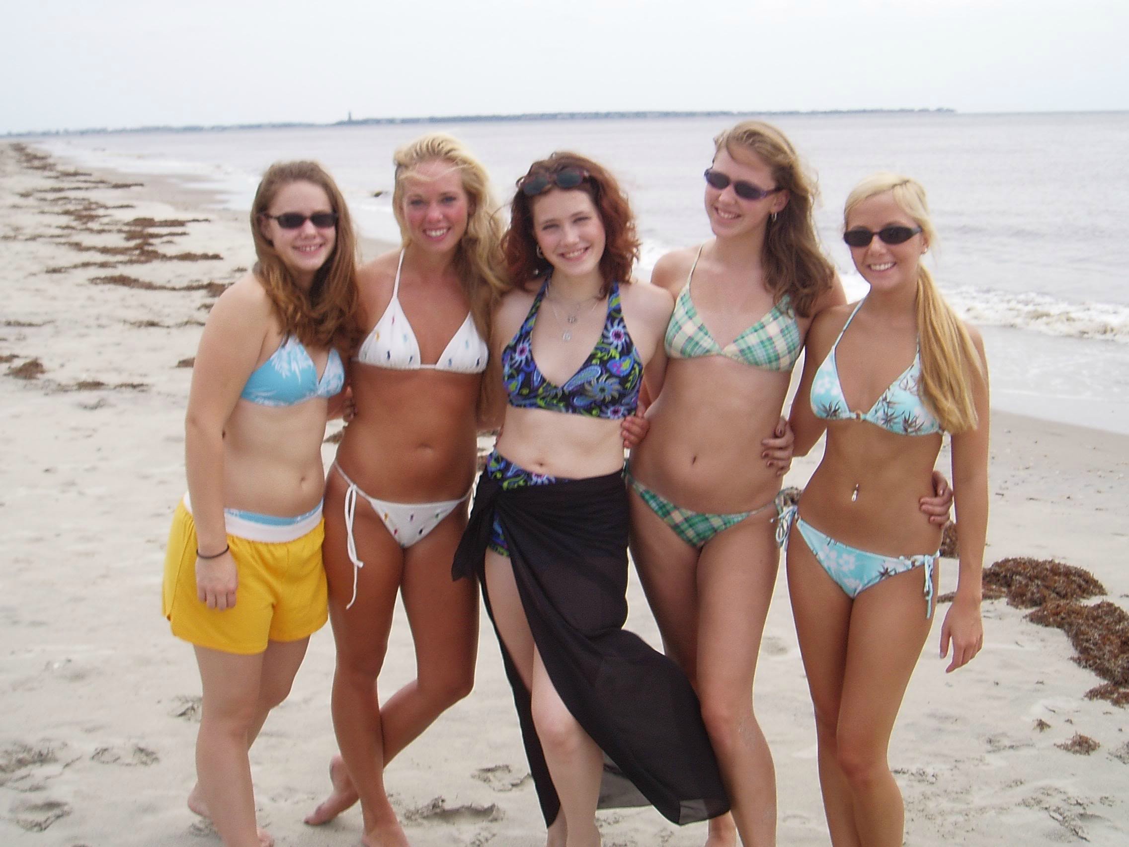 Teen cuties in bikinis on an empty beach
