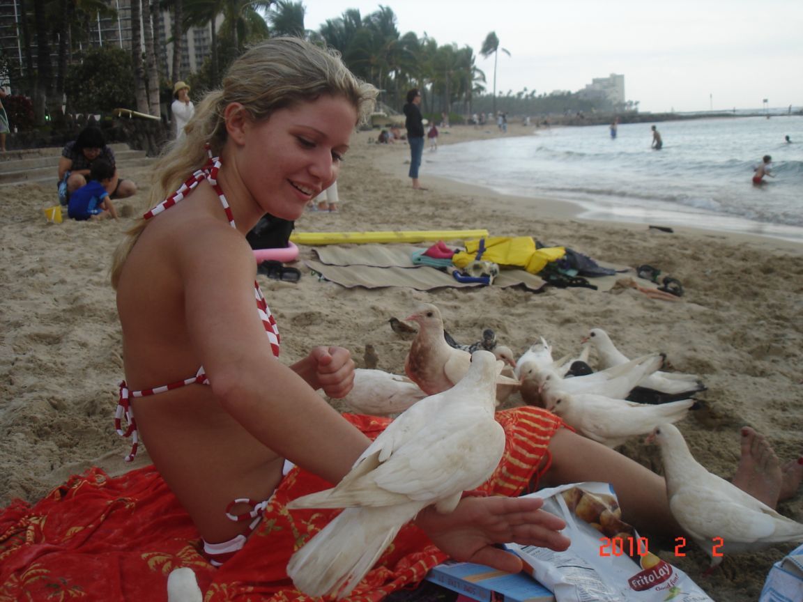 Hot chick wearing sexy swimsuit have fun with pigeons