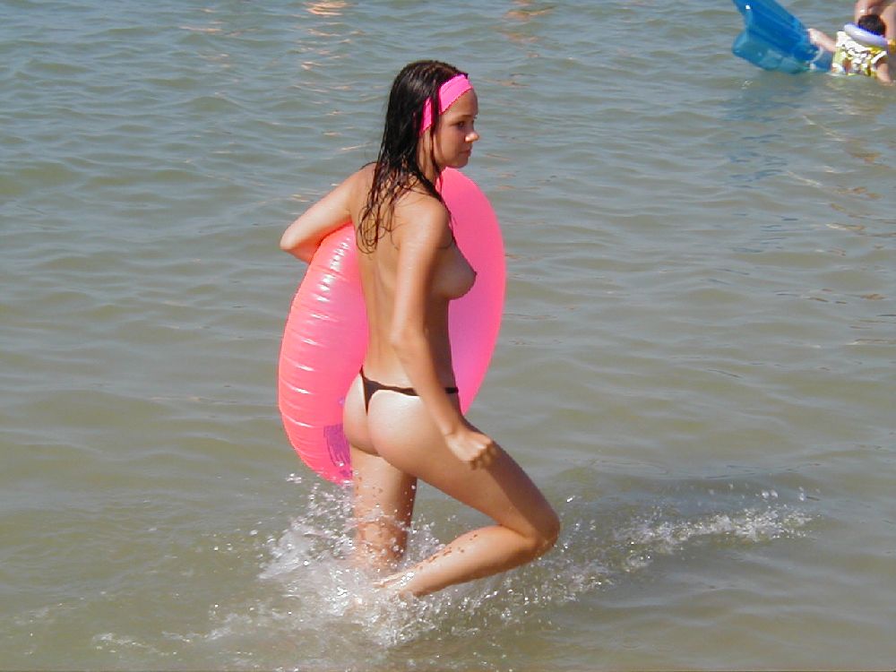 Topless sweet girl wearing blue balloon to swim with